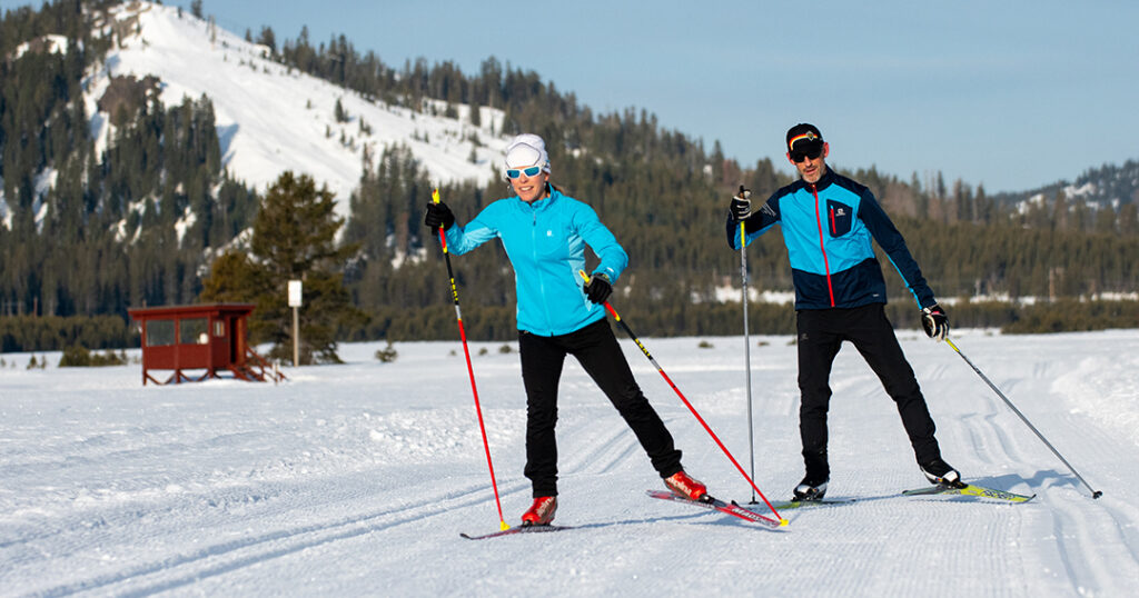 Man and woman skate skiing in Van Norden Meadow at Royal Gorge.